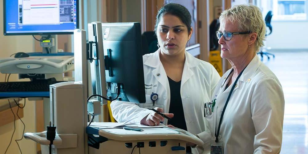 white coats looking at computer